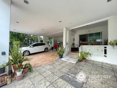 Spacious covered parking area with modern design and lush greenery