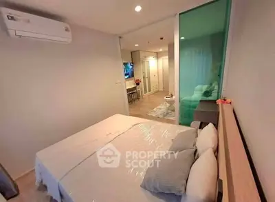 Modern bedroom with air conditioning and sliding glass door leading to living area.