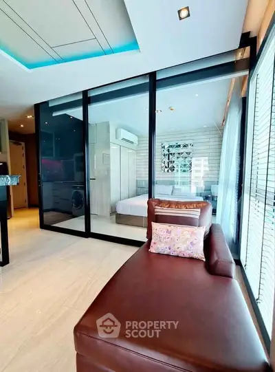 Modern open-layout living room with glass partition and stylish decor