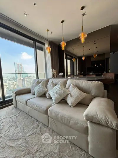 Luxurious living room with plush sofa and stunning city view through large windows.
