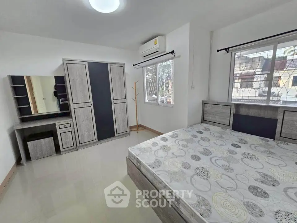 Spacious bedroom with modern furniture and large window view