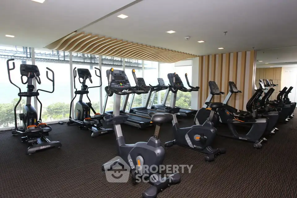 Modern gym with state-of-the-art fitness equipment and large windows offering natural light.