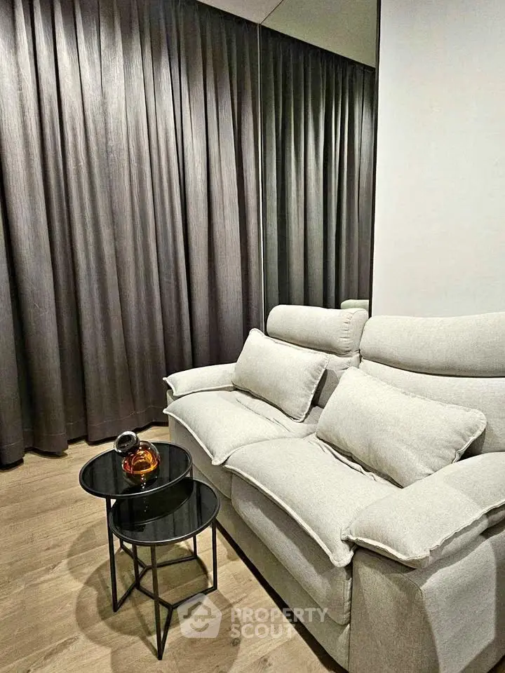 Cozy living room with plush sofa and modern side tables, perfect for relaxation.