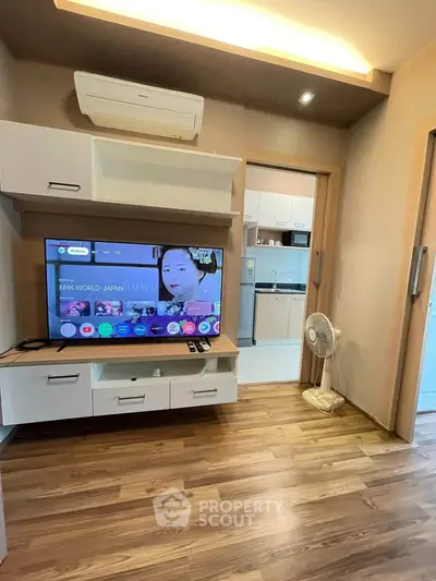 Modern living room with wooden flooring and sleek TV setup