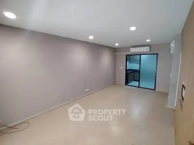 Spacious modern living room with sleek design and open kitchen view.
