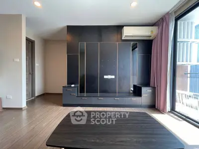 Modern living room with sleek black cabinetry and large window for natural light.