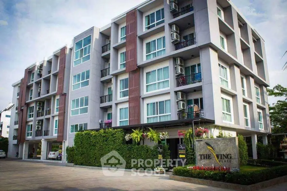 Modern apartment building with lush greenery and spacious balconies in urban setting.