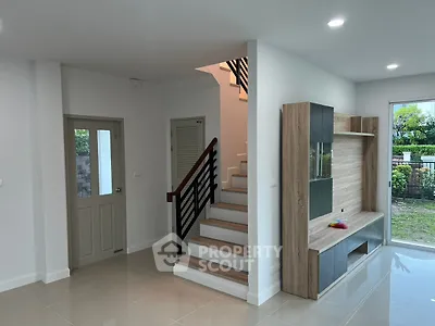 Modern interior with sleek staircase and built-in wooden entertainment unit.