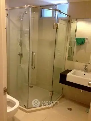 Modern bathroom with glass shower enclosure and sleek fixtures.