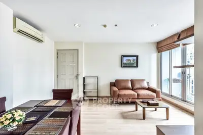 Spacious modern living room with large windows and stylish furniture in a high-rise apartment.