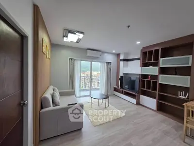 Spacious modern living room with large TV and balcony view