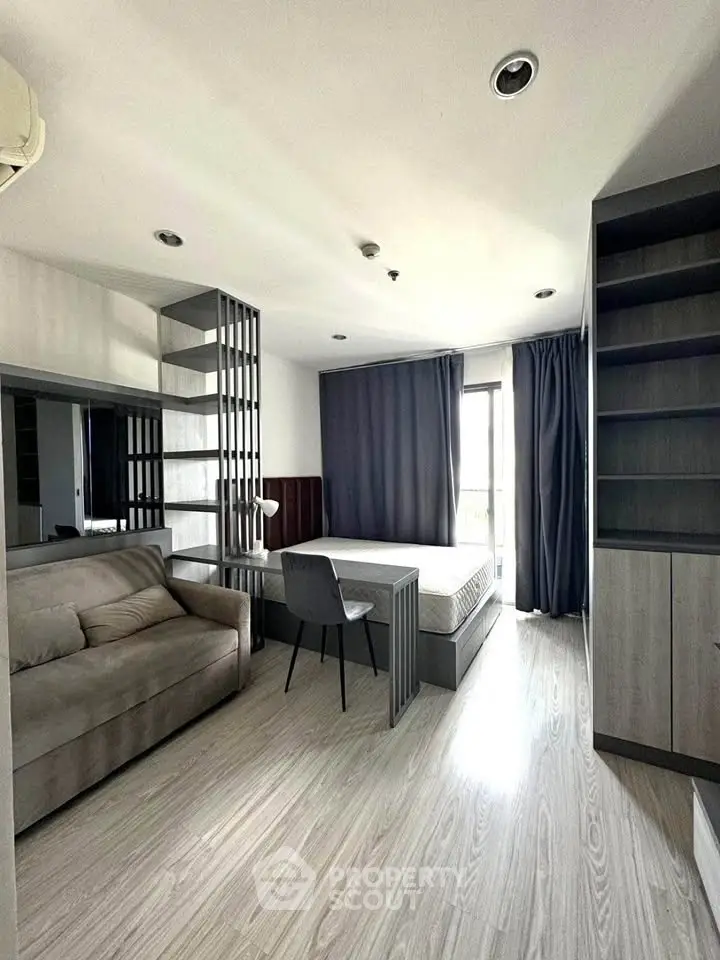 Modern studio apartment with sleek design, featuring a cozy sofa, bed, and ample storage space.