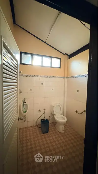 Spacious bathroom with high ceiling and modern fixtures in a well-lit home.