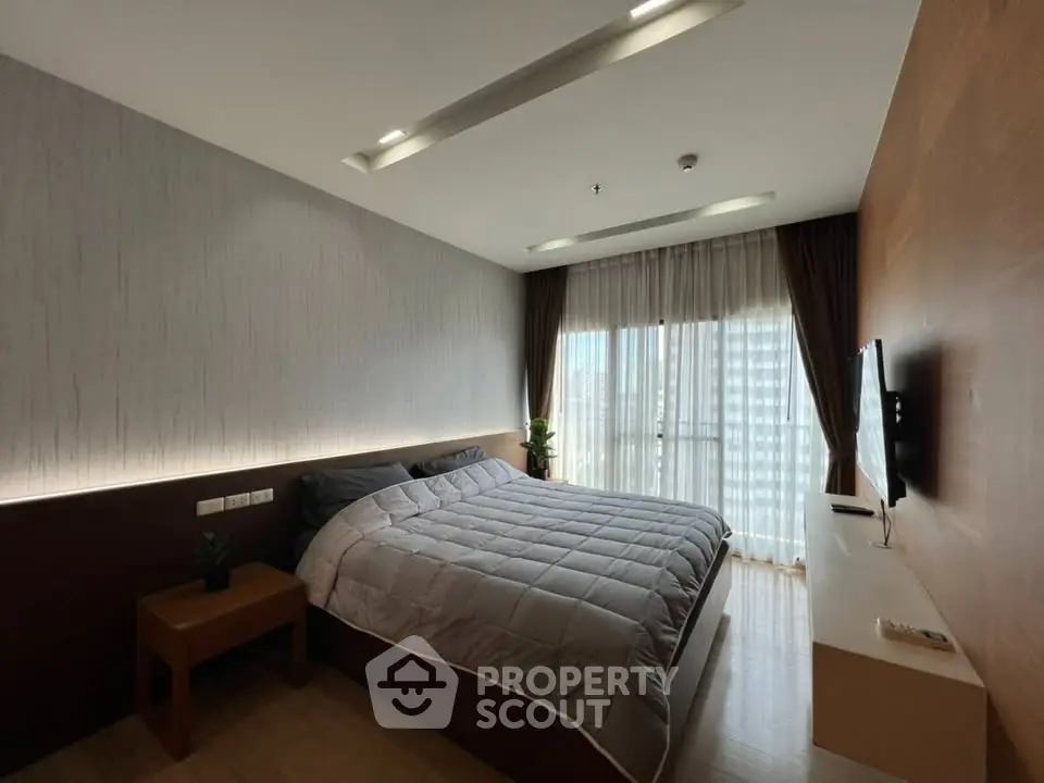 Modern bedroom with large window and stylish decor in a high-rise apartment.