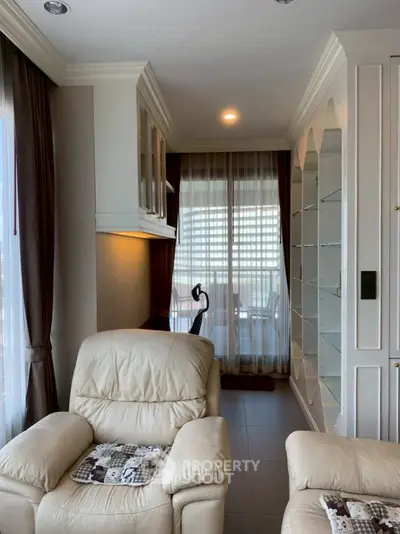 Cozy living room with plush armchairs and elegant shelving, perfect for relaxation and style.