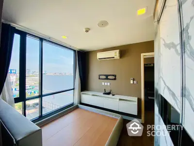 Modern bedroom with large windows and city view, featuring built-in storage and air conditioning.