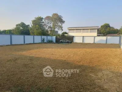 Spacious vacant land with boundary walls, ideal for development or landscaping.