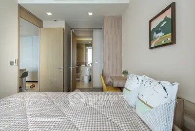 Modern bedroom with stylish decor and ensuite bathroom in a contemporary apartment.