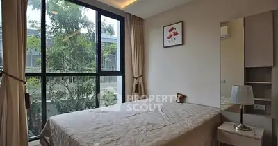 Cozy bedroom with large window and elegant decor in modern apartment.