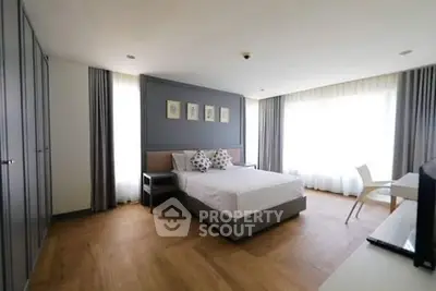 Spacious modern bedroom with large windows and elegant decor