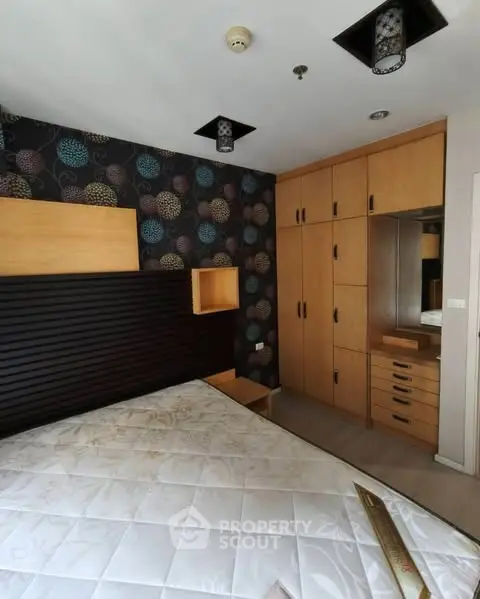 Modern bedroom with stylish wallpaper and built-in wooden wardrobe