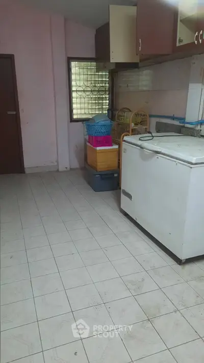 Spacious kitchen with tiled floor and ample storage space