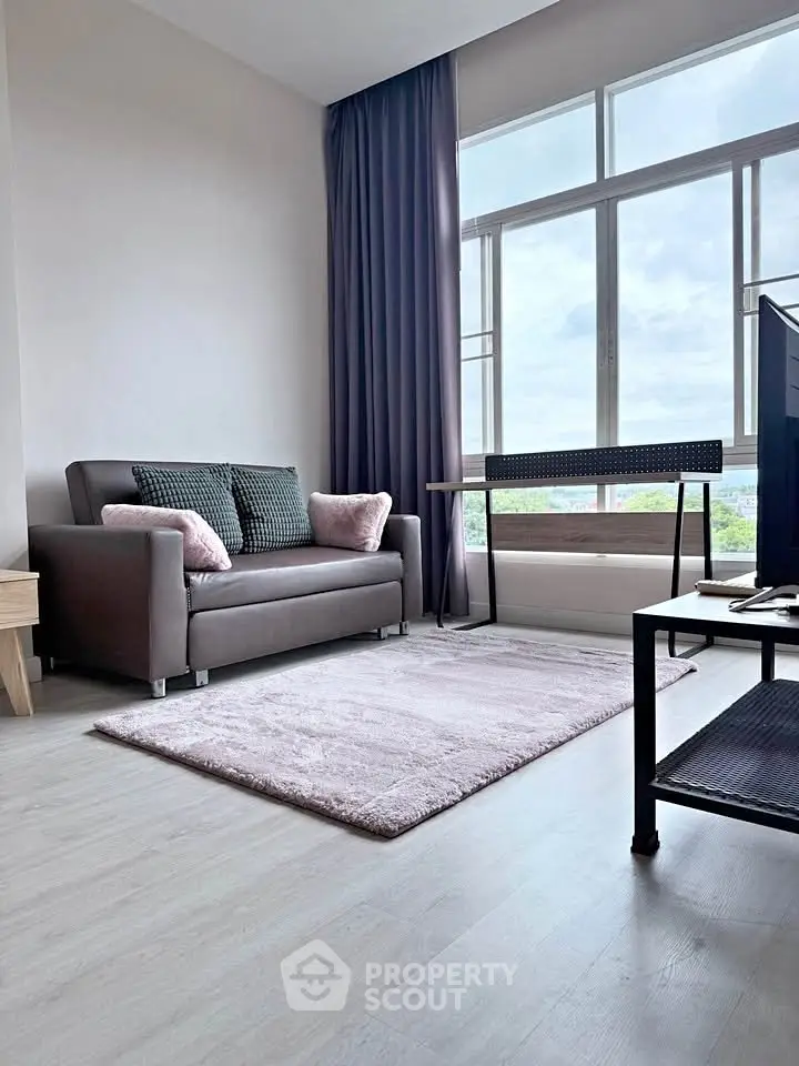 Modern living room with large window, cozy sofa, and stylish decor in a bright apartment.