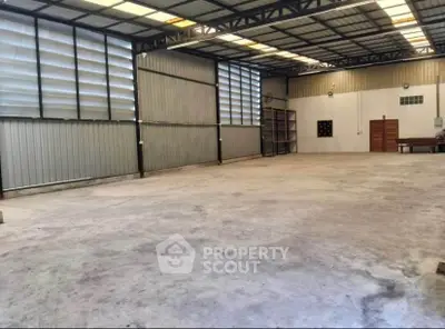 Spacious industrial warehouse with high ceilings and ample natural light.