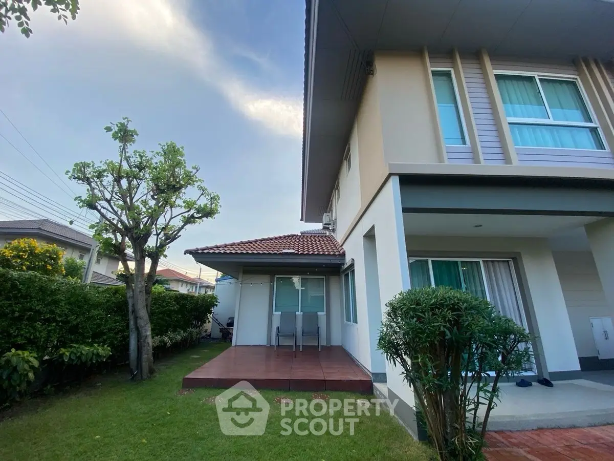 Charming two-story house with lush garden and patio, perfect for family living.