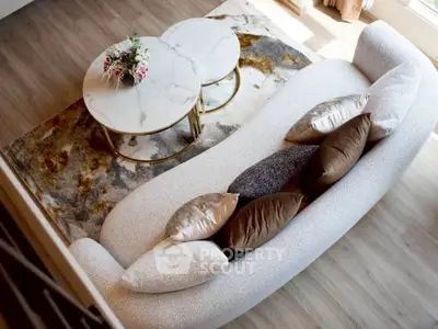 Elegant living room with stylish sofa and marble coffee tables on a chic rug.