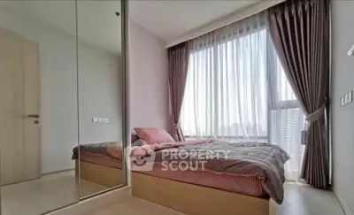 Modern bedroom with large window and mirrored closet in a stylish apartment.