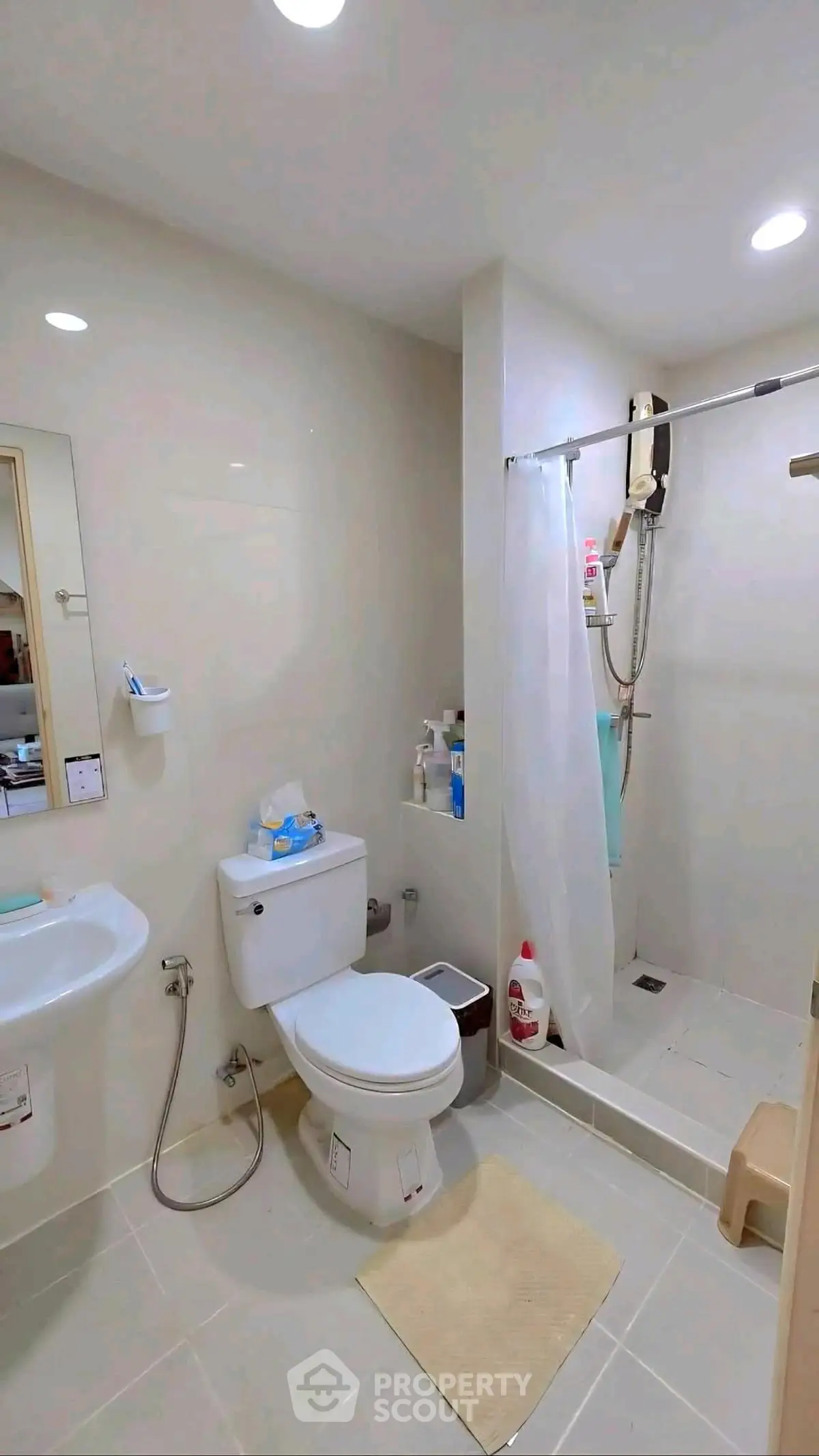 Modern bathroom with shower and toilet in a sleek, minimalist design.