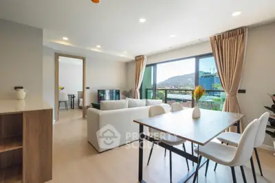 Spacious modern living room with dining area and scenic view, featuring elegant decor and natural light.