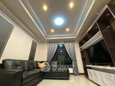 Modern living room with stylish ceiling lights and sleek black leather sofa.