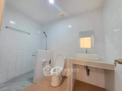 Spacious modern bathroom with sleek white tiles and contemporary fixtures.