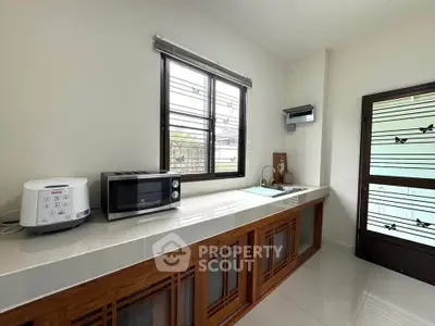 Modern kitchen with sleek countertop, microwave, and window view