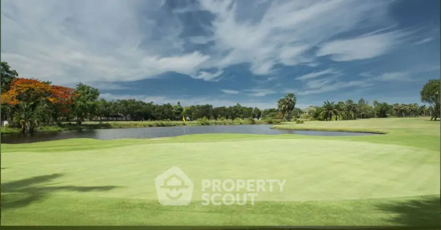 Stunning golf course view with lush greenery and serene water feature under a vibrant sky.