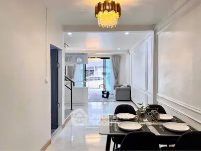 Spacious modern living and dining area with elegant chandelier and open layout.