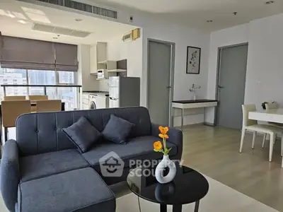Modern living room with stylish furniture and open kitchen in a bright apartment.