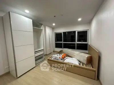 Modern bedroom with sleek wardrobe and large window, ready for furnishing.