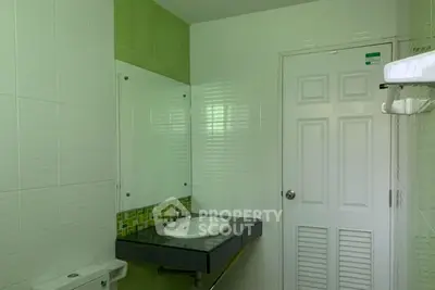 Modern bathroom with sleek sink and green tile accents