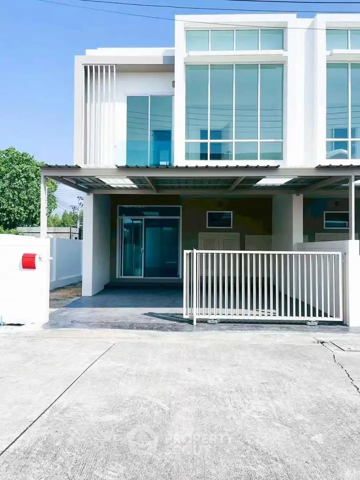 Modern townhouse with sleek glass facade and gated driveway in a serene neighborhood.