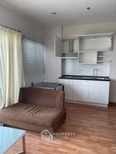 Cozy living room with modern kitchenette and natural light