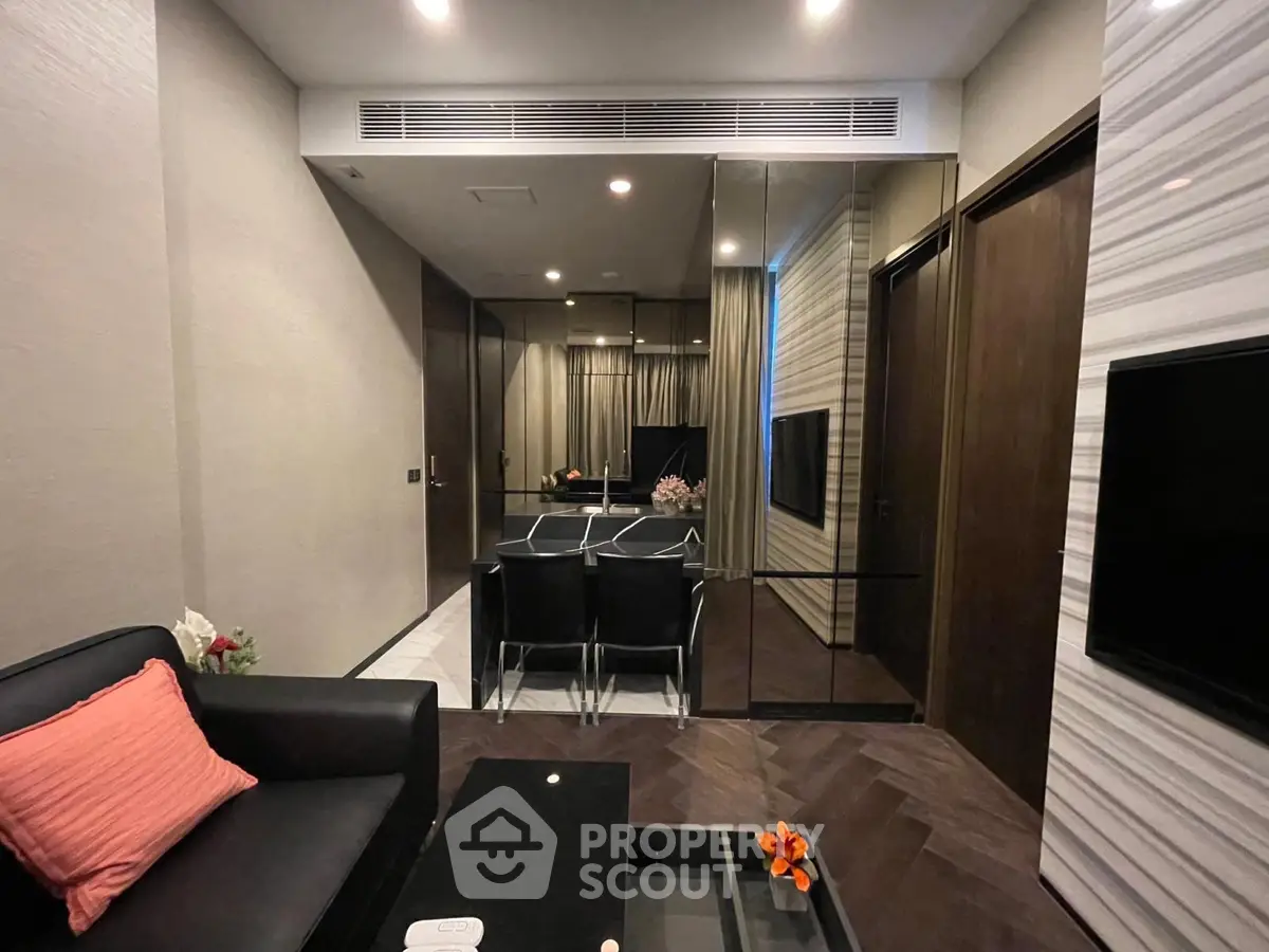 Modern living room with sleek design, mirrored walls, and elegant furniture in a luxury apartment.