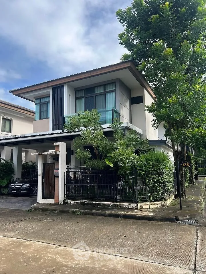Charming two-story house with lush greenery and modern design in a serene neighborhood.