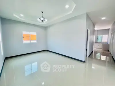 Spacious modern living room with glossy tile flooring and elegant ceiling light fixture.