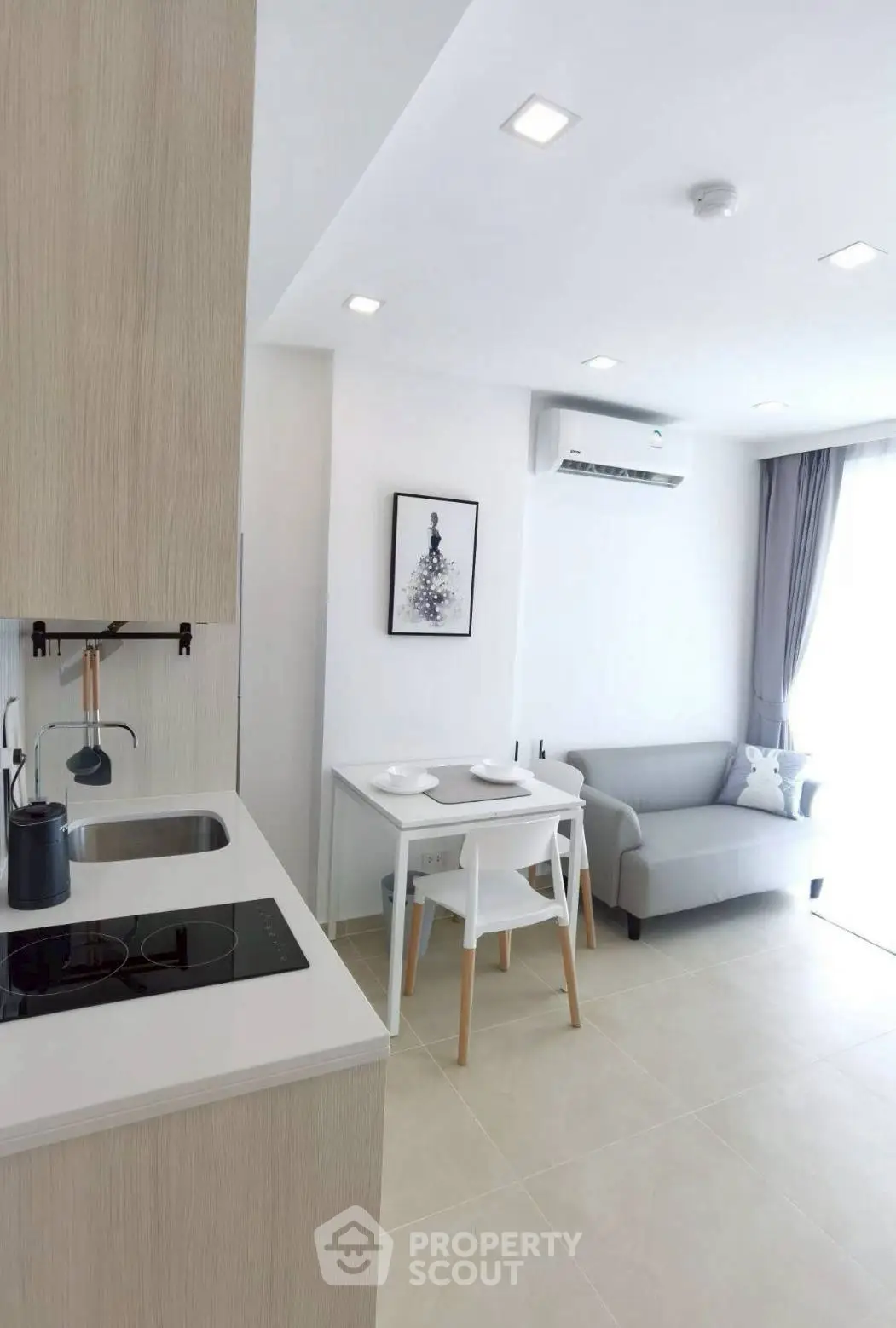 Modern living room with open kitchen, featuring sleek design and natural light.