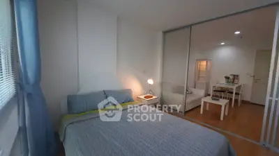 Cozy bedroom with sliding glass doors leading to a modern living area, perfect for urban living.