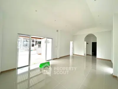 Spacious modern living room with large windows and glossy tiled floors