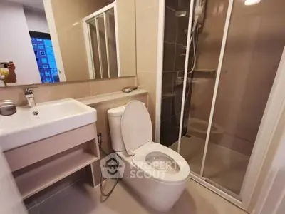 Modern bathroom with sleek fixtures and glass shower enclosure in a contemporary apartment.